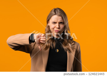 Businesswoman with sign dislike. Grimacing condemning lady showing thumbs-down 124021443