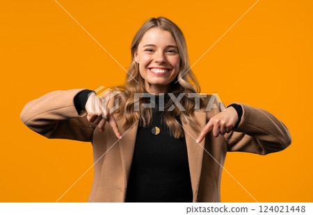 Smiling businesswoman pointing down advertising area on yellow. Click subscribe Smiling businesswoman pointing down advertising area on yellow. Click subscribe 124021448