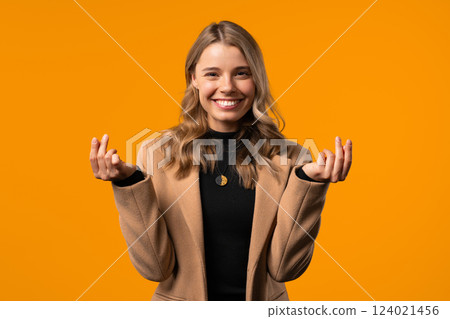 Young Businesswoman With Money Gesture On Yellow Studio Background. Smart 124021456