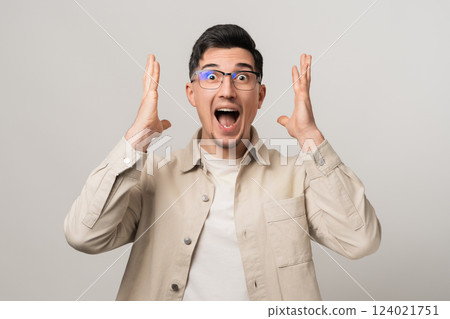 Pure panic. Man in eyeglasses and a beige overshirt screaming in shock, hands on his head. The moment of realizing he forgot about taxes, dramatic emotion 124021751