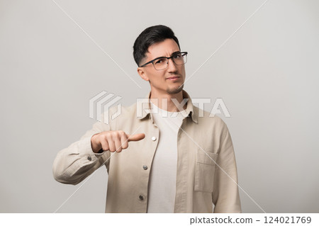 Lost in decision. An uncertain man with eyeglasses holding a Roman deciding thumb, deep in thought with a doubtful expression. Classic gesture meets modern indecision 124021769