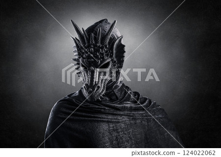 Black dragon with hooded cloak over dark misty background with clipping path 124022062