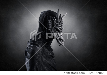 Black dragon with hooded cloak over dark misty background with clipping path 124022065