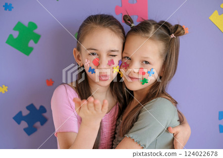 A girl blows a kiss while hugging her sister with autism spectrum disorder. Problems of education 124022678