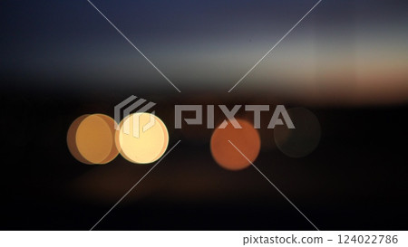 Blurred lights evening city traffic bokeh. Defocused night city traffic. Blurred lights bokeh car headlights driving evening city road. City night traffic background 124022786