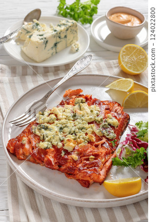 baked salmon topped with blue cheese on a plate 124022800