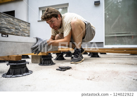 Leveling wooden beams for outdoor deck installation Leveling wooden beams for outdoor deck installation 124022922