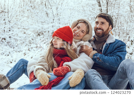 Young cute family enjoying winter day in a forest Young cute family enjoying winter day in a forest 124023270