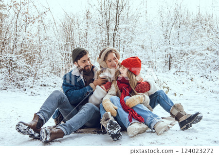 Young cute family enjoying winter day in a forest 124023272