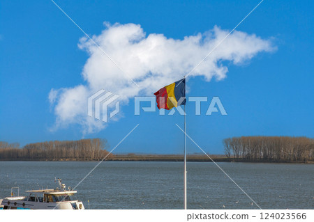 National Romanian flag over Danube river banks in Romania. National Romanian flag over Danube river banks in Romania. 124023566