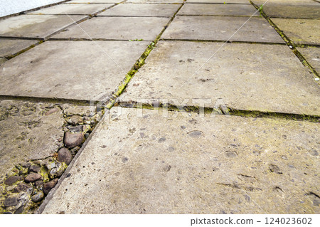 Old and broken cracked concrete floor tiles Old and broken cracked concrete floor tiles 124023602