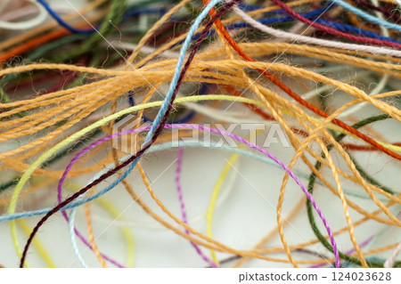 Multi-colored tangled colorful needlecraft silk thread rope. Macro shot. Abstract colors background 124023628