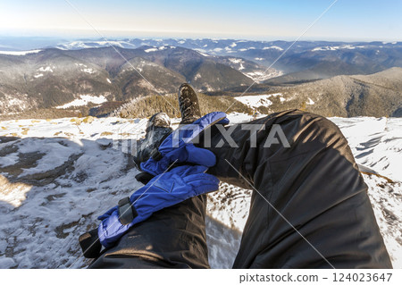 Mens legs in winter shoes against panorama over the Carpathian mountains. Mens legs in winter shoes against panorama over the Carpathian mountains. 124023647