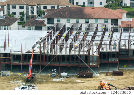 Industrial construction site with workers assembling metal frame building. Development of residential housing in America. Real estate market in the USA 124023690