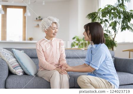 Smiling senior woman and care staff facing each other 124023719