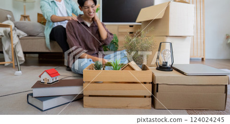 LGBTQ couple unpacking boxes and arranging their new home, highlighting teamwork and love. 124024245