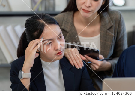 Concerned businesswoman in a meeting, discussing challenges with a colleague while reviewing data. Concerned businesswoman in a meeting, discussing challenges with a colleague while reviewing data. 124024306