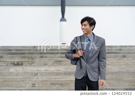 Smiling Asian businessman with backpack in casual moment 124024552