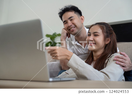 Family sharing a light moment while using a laptop 124024553