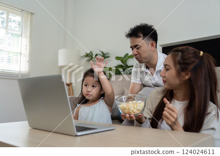 Playful Interaction and Movie Watching. A delightful family moment captured during a fun movie session at home. Playful Interaction and Movie Watching. A delightful family moment captured during a fun movie session at home. 124024611