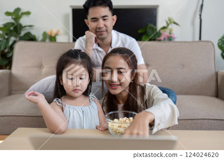 Family under a blanket, sharing a fun movie moment Family under a blanket, sharing a fun movie moment 124024620