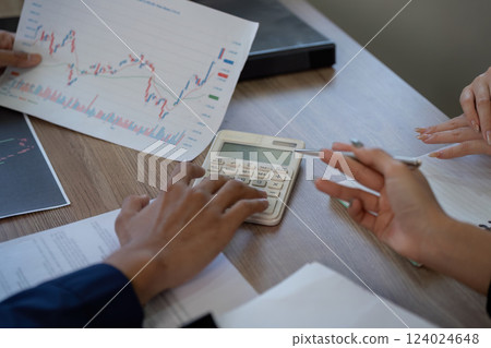 Finance and Analysis. A close-up of hands analyzing financial documents and using a calculator to assess data. Finance and Analysis. A close-up of hands analyzing financial documents and using a calculator to assess data. 124024648