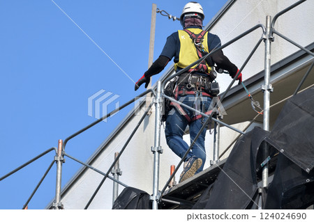 Large-scale repair work on an apartment building - Scaffolding workers assembling temporary scaffolding 124024690