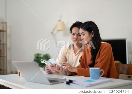 Couples' financial planning. Engaged couple discussing their finances at home, looking concerned and focused on their budget. Couples' financial planning. Engaged couple discussing their finances at home, looking concerned and focused on their budget. 124024734