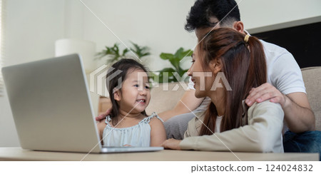 Family enjoying quality time together while using a laptop at home Family enjoying quality time together while using a laptop at home 124024832