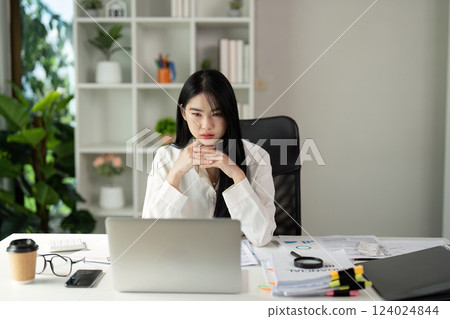 Tax Analysis Focus. A young professional woman analyzing data on her laptop in a modern office environment. Tax Analysis Focus. A young professional woman analyzing data on her laptop in a modern office environment. 124024844