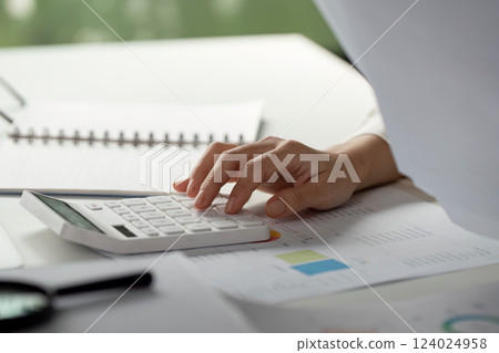 Tax calculation. Close-up of a hand calculating financial numbers with a calculator. Tax calculation. Close-up of a hand calculating financial numbers with a calculator. 124024958