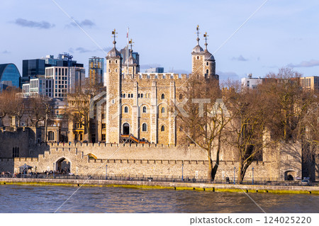 The Tower of London rises dramatically by the River Thames, showcasing its historic architecture amid modern city skyscrapers. Visitors admire its rich history and stunning views. The Tower of London rises dramatically by the River Thames, showcasing its historic architecture amid modern city skyscrapers. Visitors admire its rich history and stunning views. 124025220
