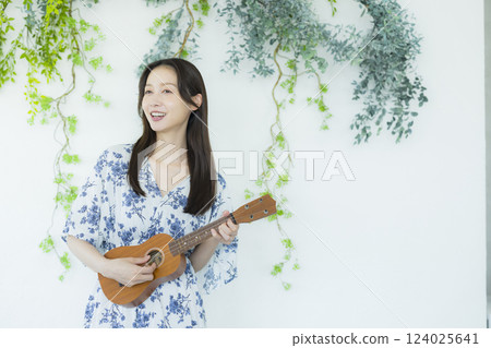 A woman playing an ukulele 124025641