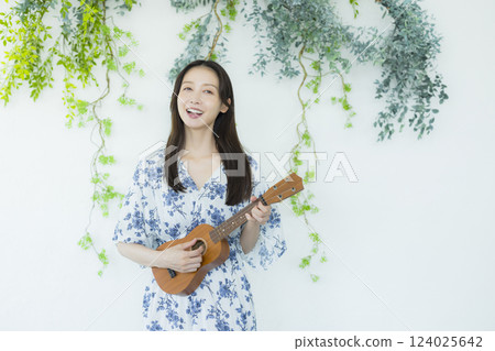 A woman playing an ukulele 124025642