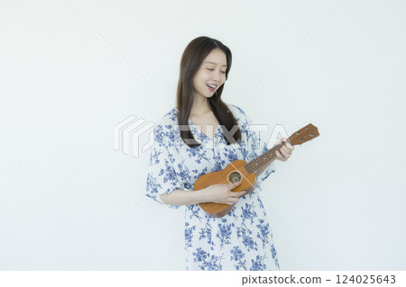 A woman playing an ukulele A woman playing an ukulele 124025643