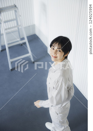 一位身著工作服的女士走過倉庫 一位身著工作服的女士走過倉庫 124025994