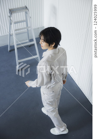 一位身著工作服的女士走過倉庫 124025999