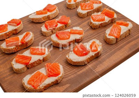 Salmon sandwiches. Buckwheat bread, cream cheese and salmon in sandwiches on a wooden board. 124026059