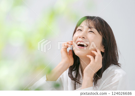 Portrait of a smiling woman in her 50s doing skin care Portrait of a smiling woman in her 50s doing skin care 124026686