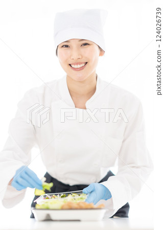 一名年輕女子在食品工廠包裝配菜 124026739