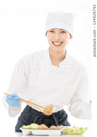 A young woman packing side dishes at a food factory 124026742