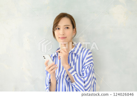 一位女士站立操作智慧型手機 124026846