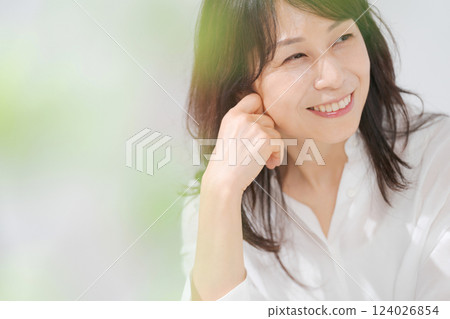 一位 50 多歲的女人坐在椅子上微笑 124026854