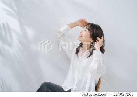 A smiling woman in her 50s sitting on a chair A smiling woman in her 50s sitting on a chair 124027265