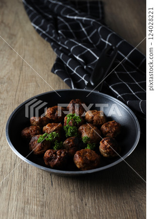 Meatballs in a pan on a wooden background Meatballs in a pan on a wooden background 124028221