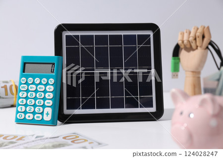 Portable solar panel with calculator and money Portable solar panel with calculator and money 124028247