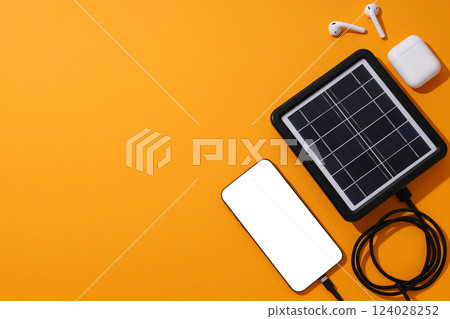 Portable solar panel with headphones and smartphone 124028252