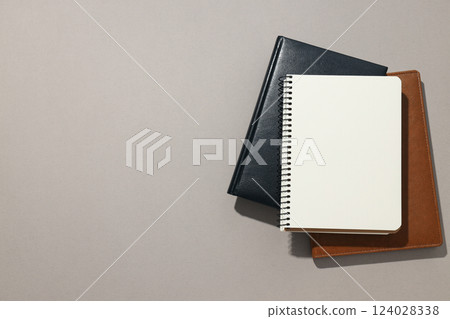 Notebooks of different colors lie on a light background 124028338