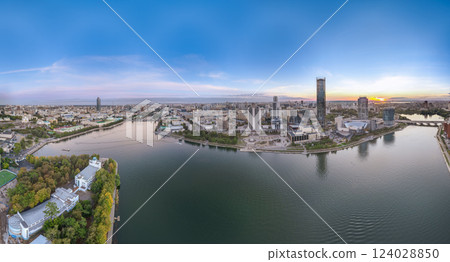 Yekaterinburg city and pond aerial panoramic view at summer or early autumn sunset. Night city in the early autumn or summer. Yekaterinburg city and pond aerial panoramic view at summer or early autumn sunset. Night city in the early autumn or summer. 124028850