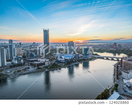 Yekaterinburg city and pond aerial panoramic view at summer or early autumn sunset. Night city in the early autumn or summer. Yekaterinburg city and pond aerial panoramic view at summer or early autumn sunset. Night city in the early autumn or summer. 124028860